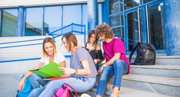 escolas de alemão - estudantes sentados nas escadas da entrada da academia
