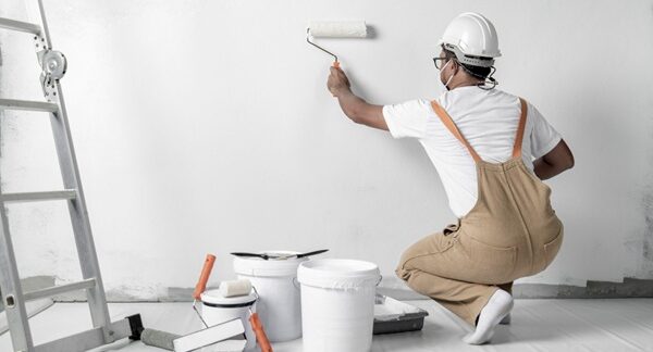 empresas de pintura residencial - Pintor de uma das melhores empresas de pintura residencial realizando um trabalho em uma casa